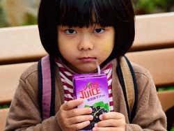 Enfant buvant du jus de fruits à Hong Kong